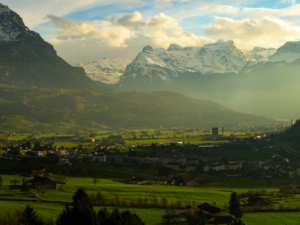 Foto di una piccola città circondata da colline e montagne