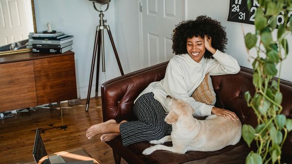 Foto junge Frau auf Sofa mit Hund